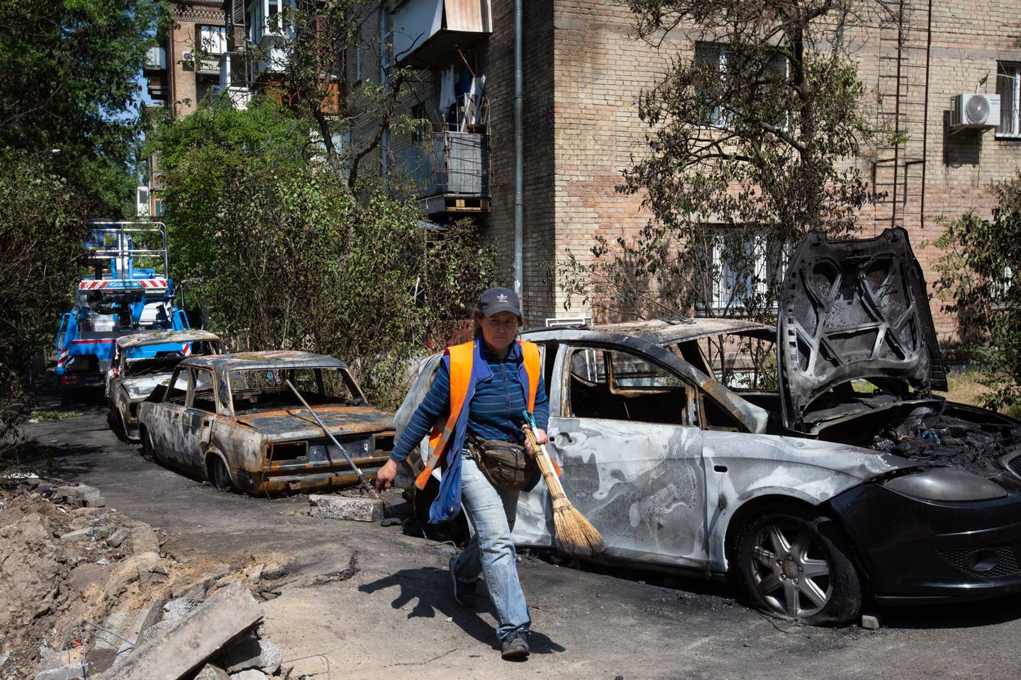 KYIV, UKRAINE - MAY 30: Utility worker walks near cars destroyed by a Russian drone explosion in central Kyiv, Ukraine on May 30, 2023. (Photo by Oleksii Chumachenko/Anadolu Agency via Getty Images)