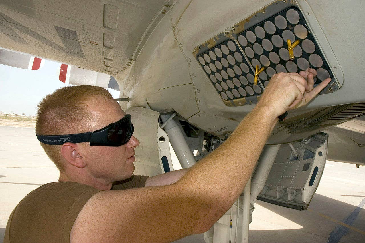 A sailor services an AN/ALE-47 countermeasures dispenser on a P-3 Orion. (USN)