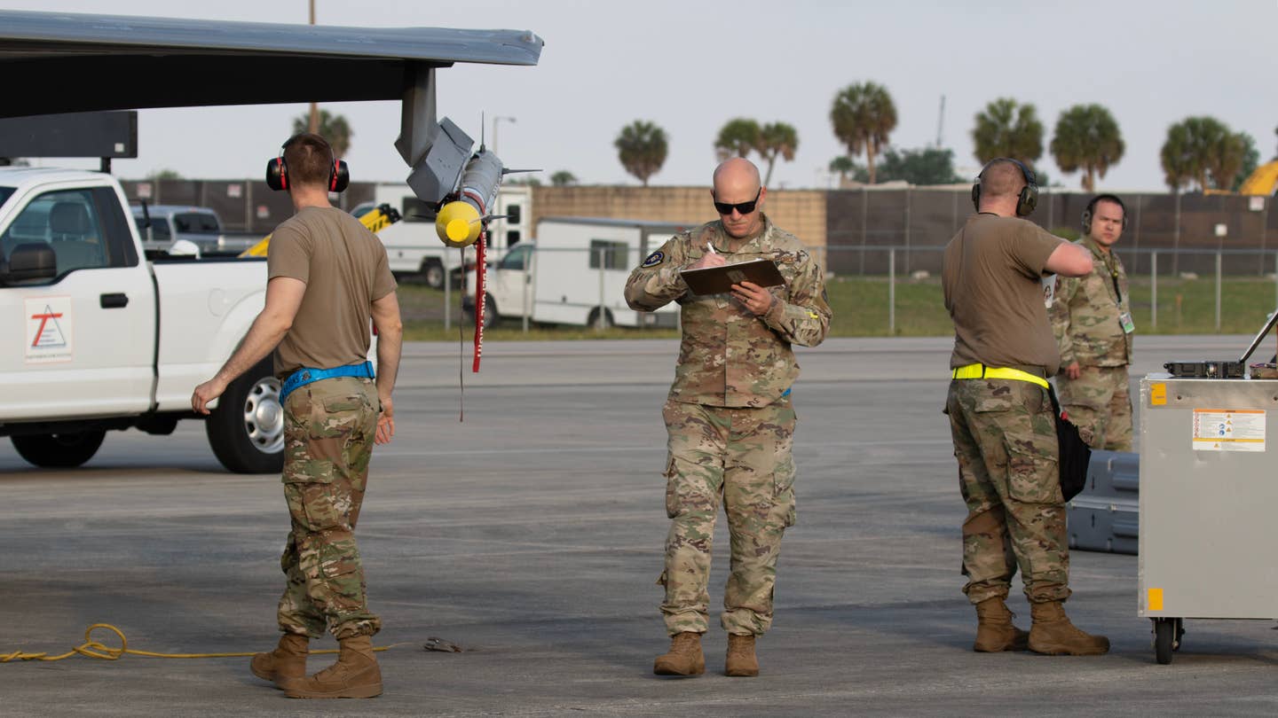 An evaluator from the 83rd Fighter Weapons Squadron checks the loading of an AIM-9X. <em>Richard Collens</em>