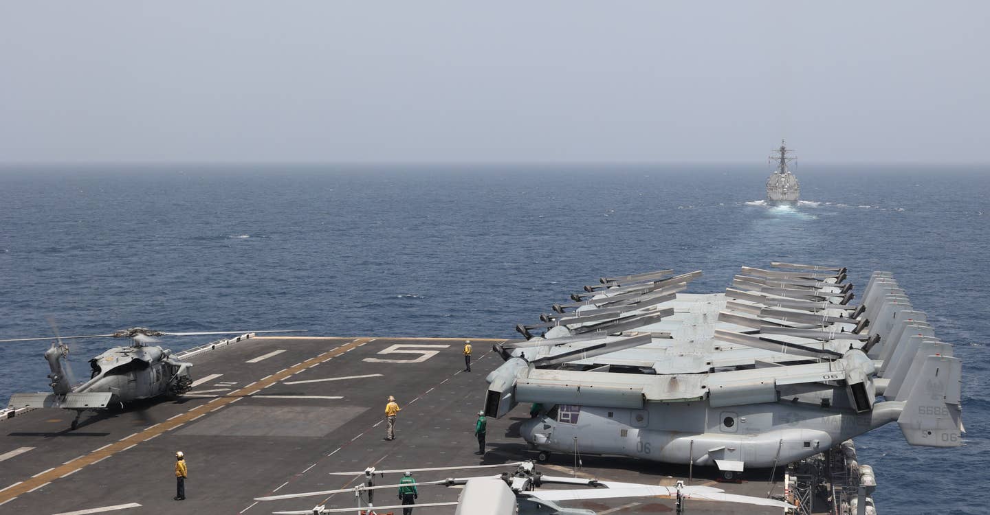 A view across the flight deck of the <em>Wasp</em> class amphibious assault ship USS<em> Bataan</em> as it sailed in the Gulf of Oman on August 17, 2023. The <em>Arleigh Burke</em> class destroyer USS <em>Thomas Hudner</em> is seen out in front to the right. USN