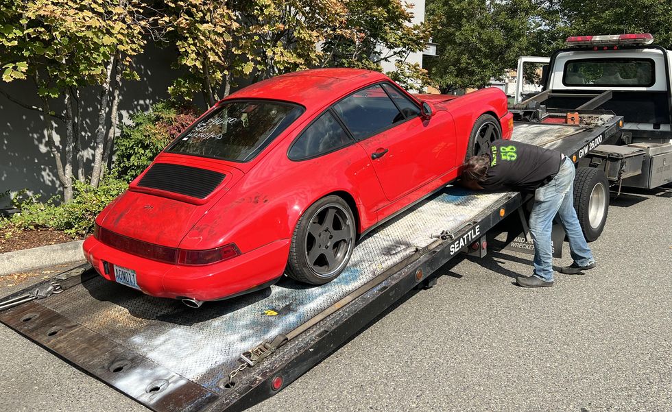 red porsche 911 on a flat bed tow truck