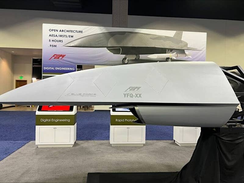 A view of Blue Force Technologies' booth at a past iteration of the Air & Space Forces Association's main annual conference in Washington, D.C., with concept art showing an AIM-120 missile-armed Fury and a nose section with the notional YFQ-XX nomenclature written on the side. <em>Andrew Van Timmeren/LinkedIn</em>