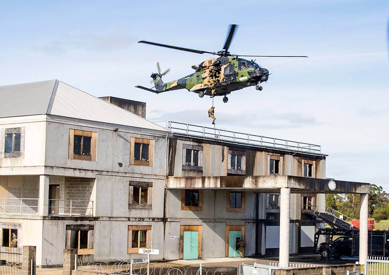 Australian Special Operations assault team members from the 2nd Commando Regiment fast-rope from a 6th Aviation Regiment MRH90 Taipanh helicopter at the Special Forces Training Center at Holsworthy Barracks in Sydney. <em>COMMONWEALTH OF AUSTRALIA, DEPARTMENT OF DEFENSE</em>