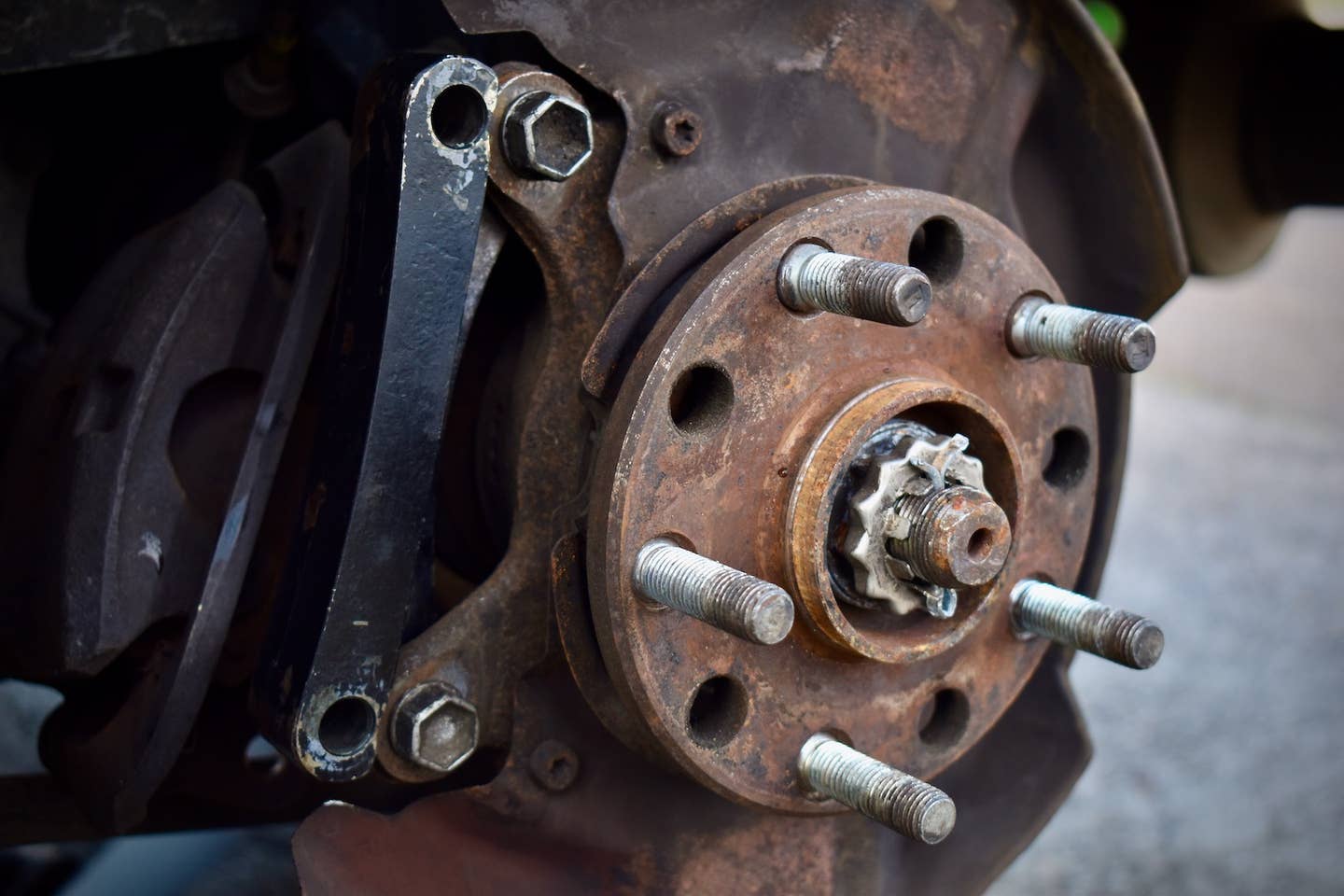 Rear hub of a Toyota MR2 with a bracket for a larger brake caliper.