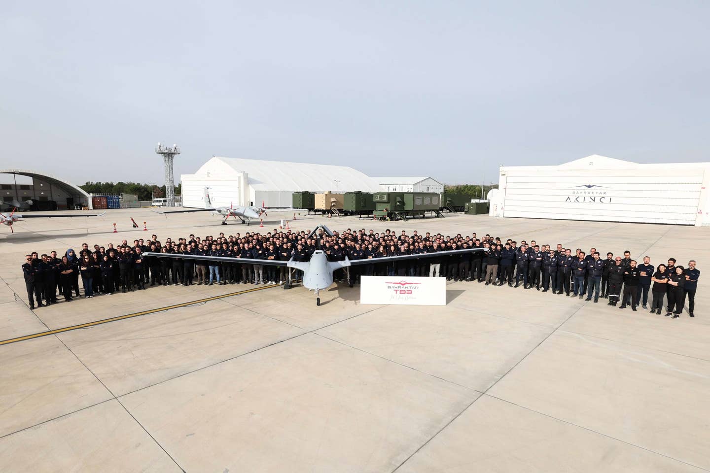 Bayraktar and Baykar employees pose for a photograph with TB3. <em>Baykar</em>