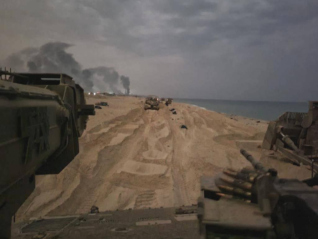 An IDF bulldozer is seen at right among other Israeli vehicles advancing along a section of beach in the Gaza Strip. (IDF)