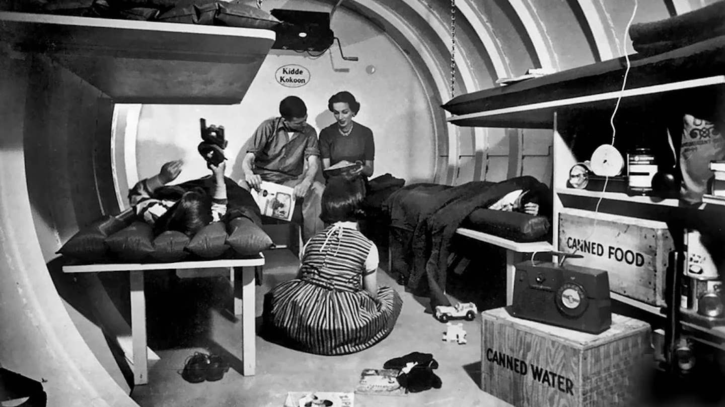 A family rests in their at-home nuclear fallout shelter