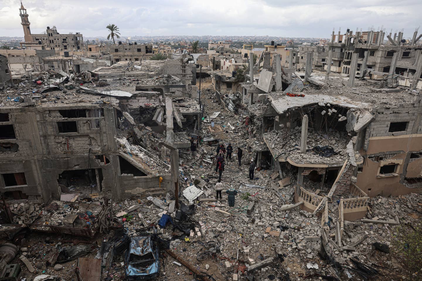 Palestinians inspect the destruction caused by Israeli strikes on their homes in the village of Khuzaa, east of Khan Yunis near the border fence between Israel and the southern Gaza Strip on November 27, 2023. (Photo by SAID KHATIB/AFP via Getty Images)