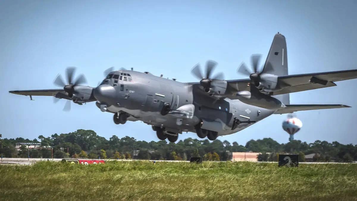 An AC-130J with the original modified M102 howitzer installed, seen sticking out of the rear left-hand side of the fuselage. <em>USAF</em>