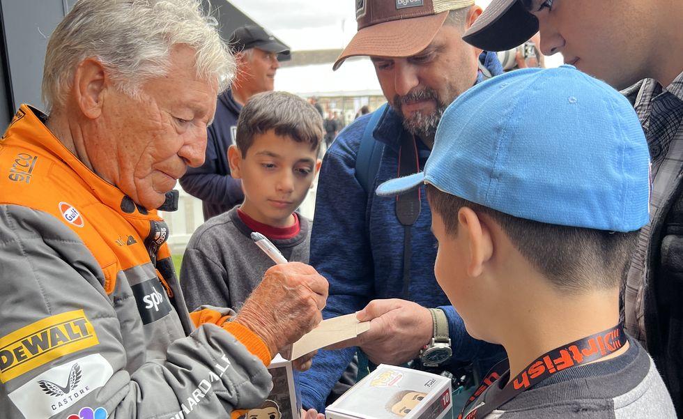 a man handing a boy a piece of paper