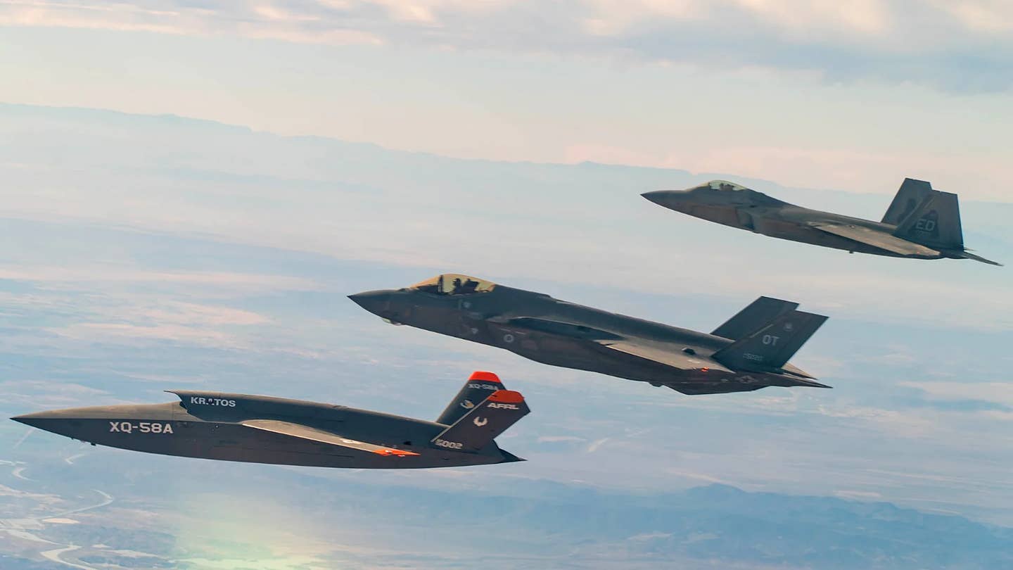 An F-35A, at center, flies together with a Kratos XQ-58 Valkyrie drone, at left, and an F-22 Raptor stealth fighter, at right, during a test. <em>USAF</em>