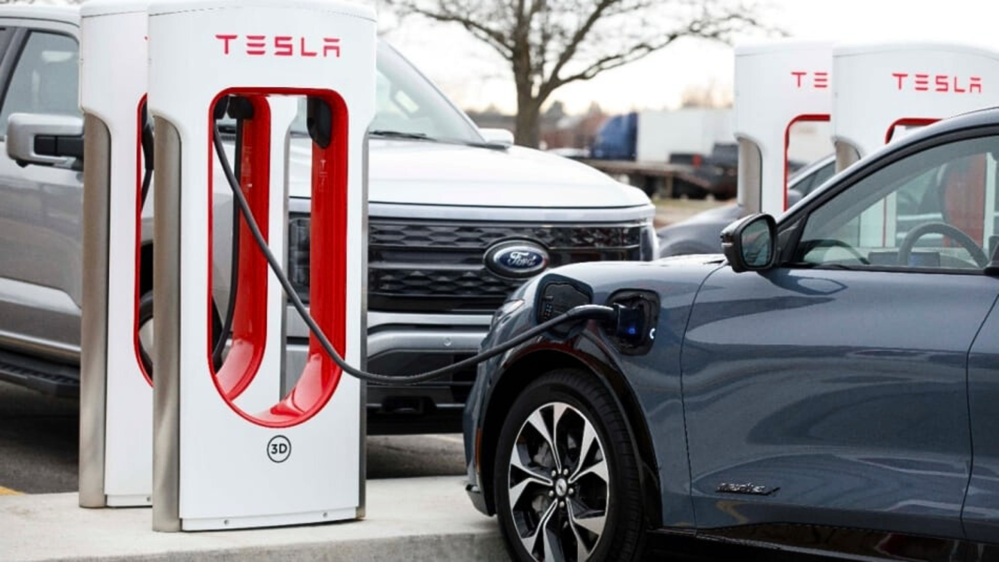 a truck and a car parked at Tesla Supercharger