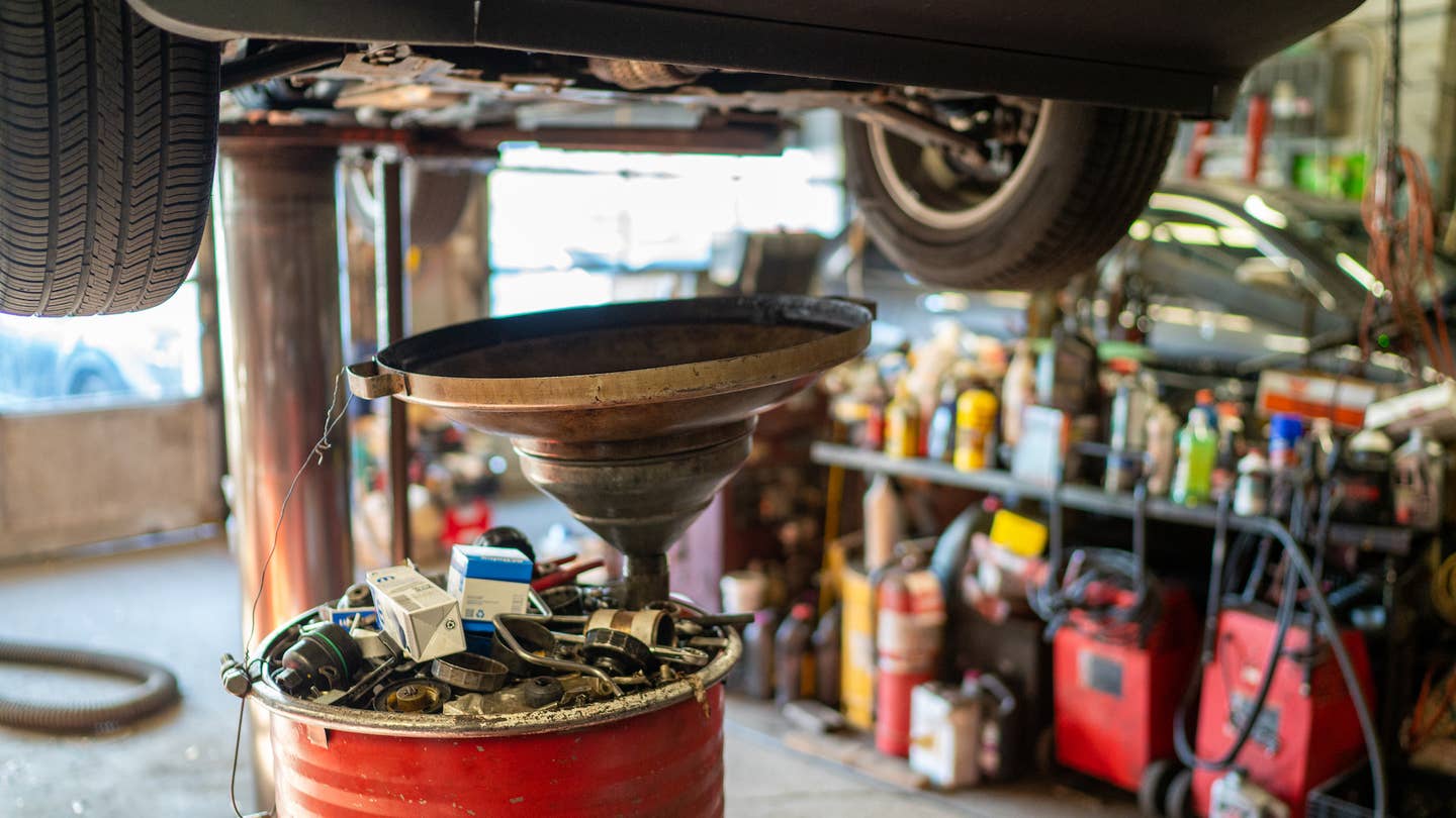 NEW YORK, NY - NOVEMBER 2: An oil barrel is placed underneath a car during an oil change November 2, 2023 in New York City. The average price for an oil change in New York City using synthetic oil is over $100. (Photo by Robert Nickelsberg/Getty Images)