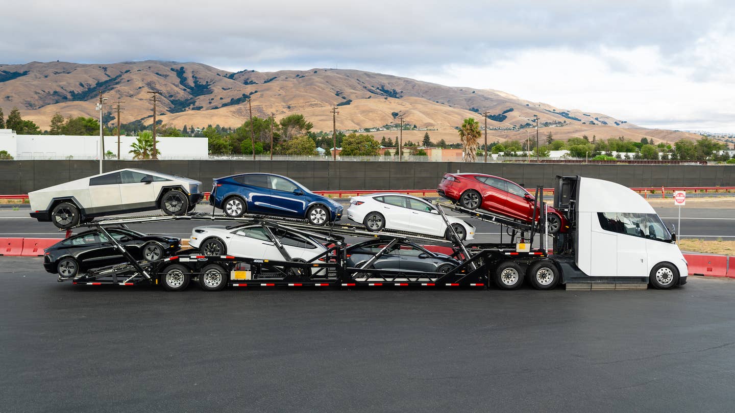 A car trailer with several Teslas on it